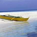 Une bangka sur du sable blanc aux Philippines